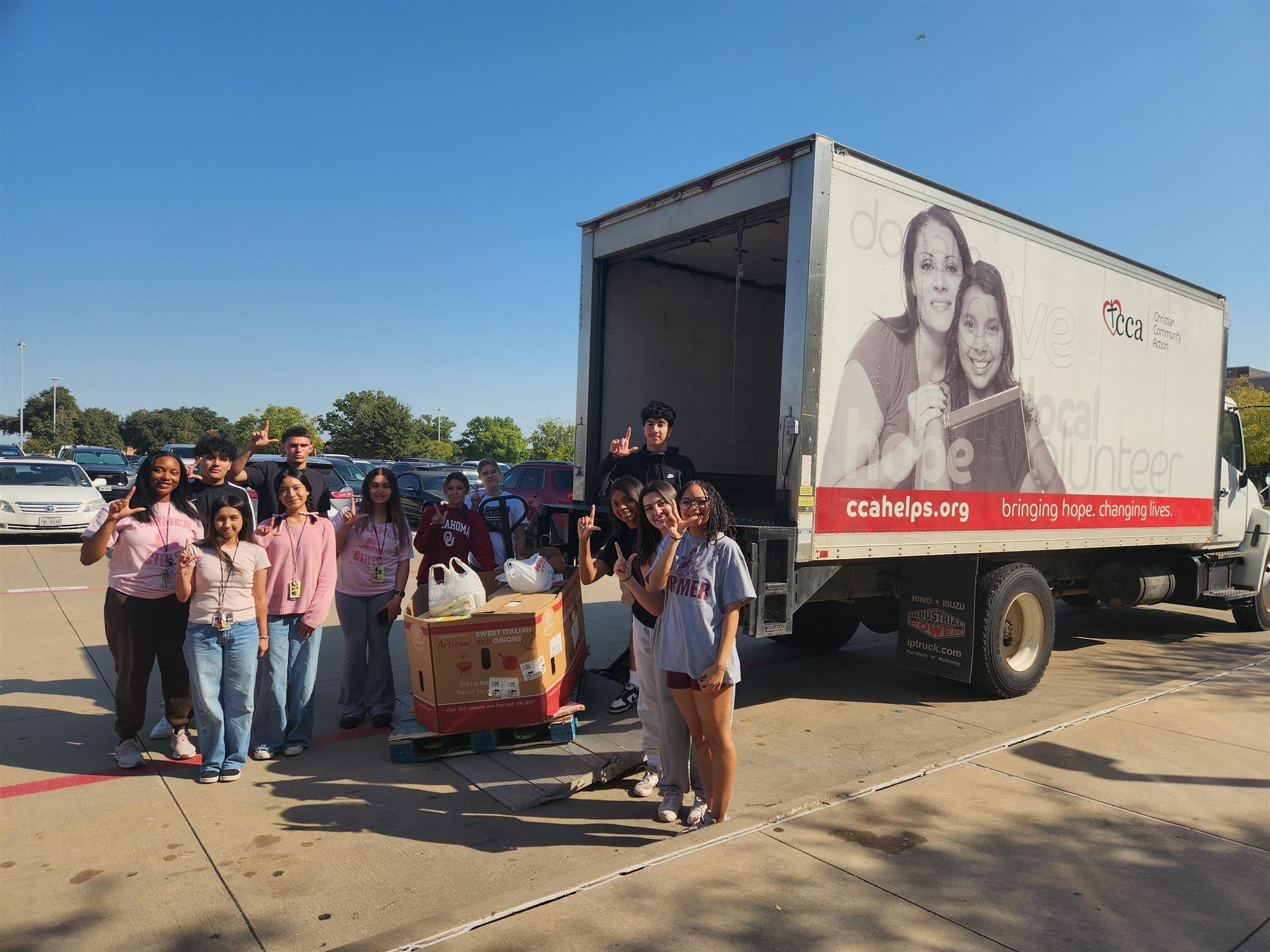 Lewisville High School students pose next to CCA truck with donations for this year's food drive. October 2024
